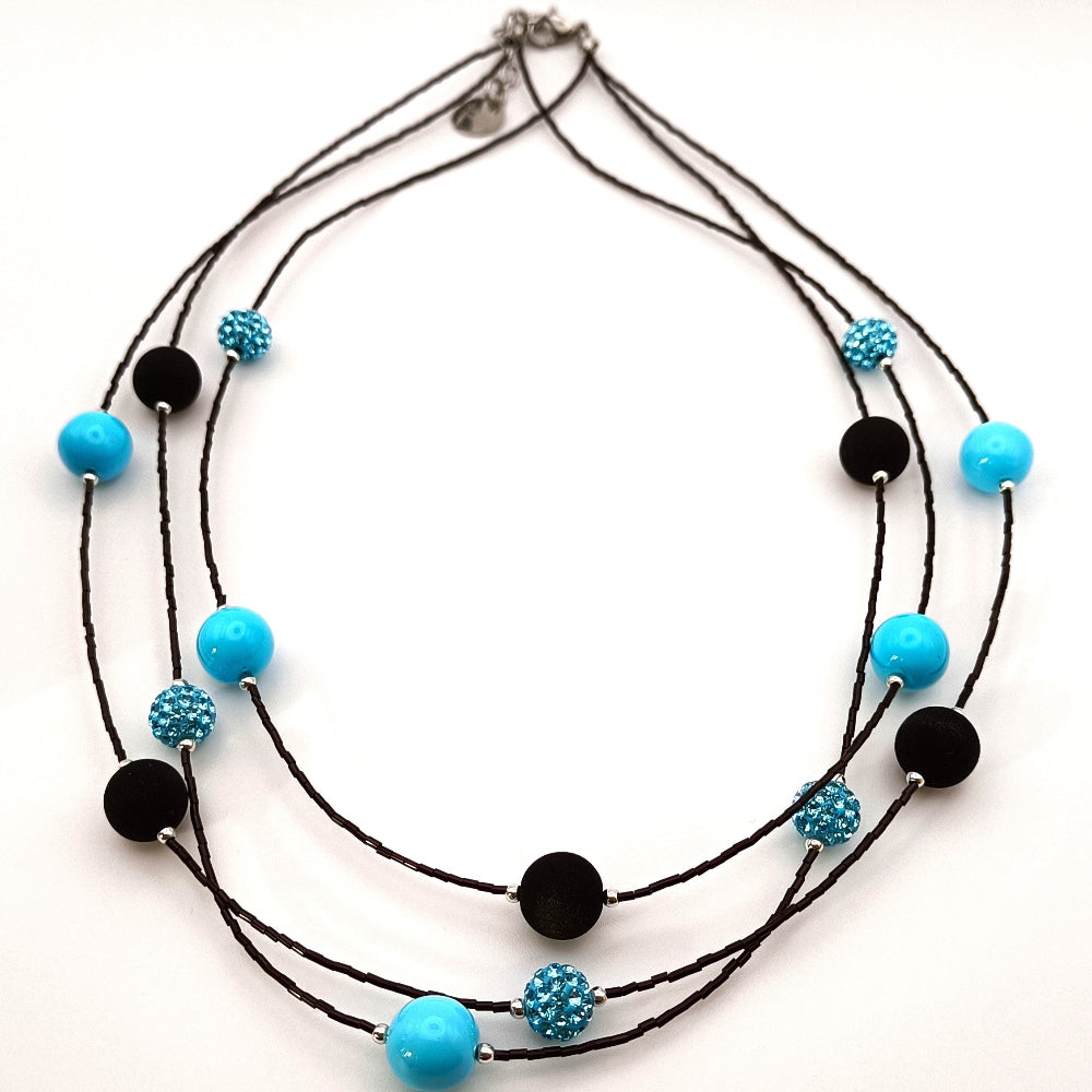 Collana a tre fili con perle nere in pietra lavica sintetizzata e cristalli Swarovski azzurri