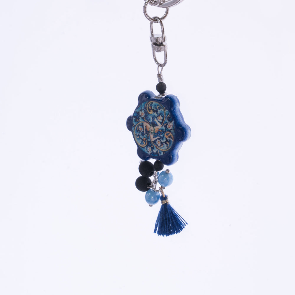 Dettaglio ceramica blu con decorazioni artistiche ornamentali e perle azzurre nere - portachiavi artigianale
